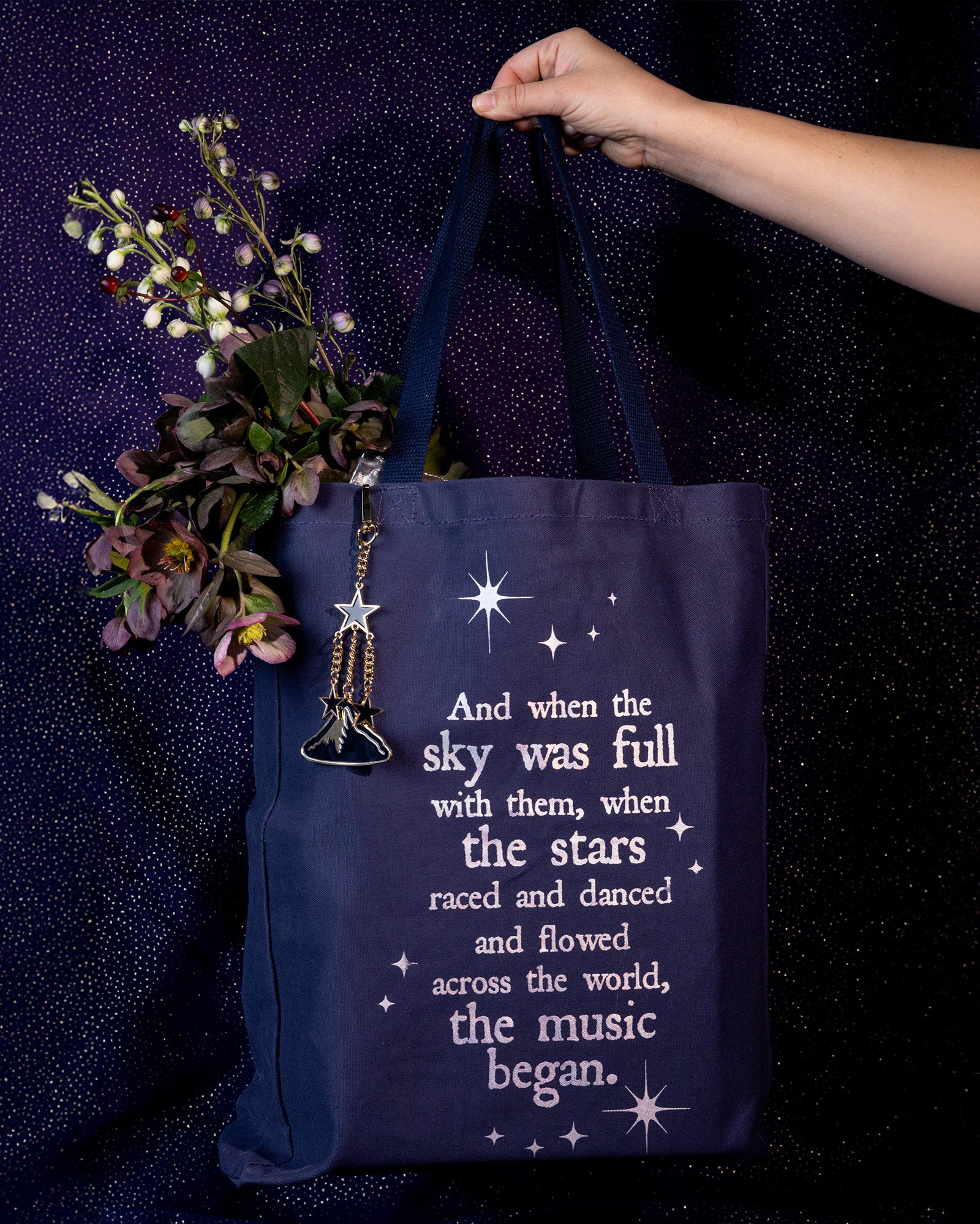 model holding navy tote bag with white text and star graphics