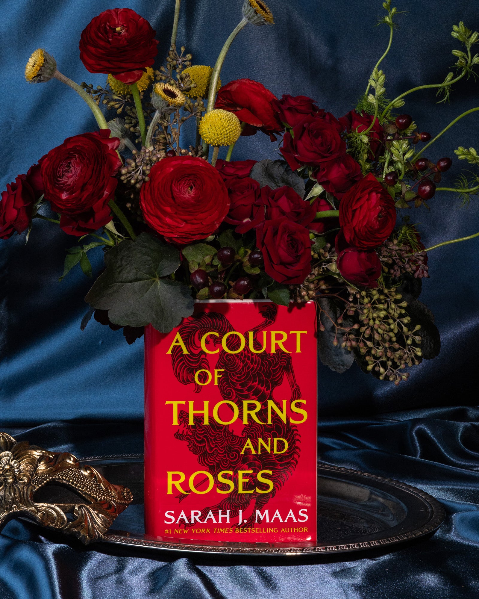 Book-shaped vase with 'A Court of Thorns and Roses' design with bouquet inside