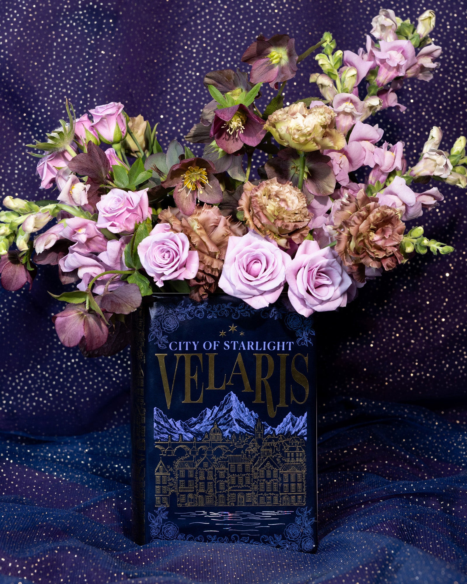Book-shaped vase with 'Velaris' design with a bouquet inside