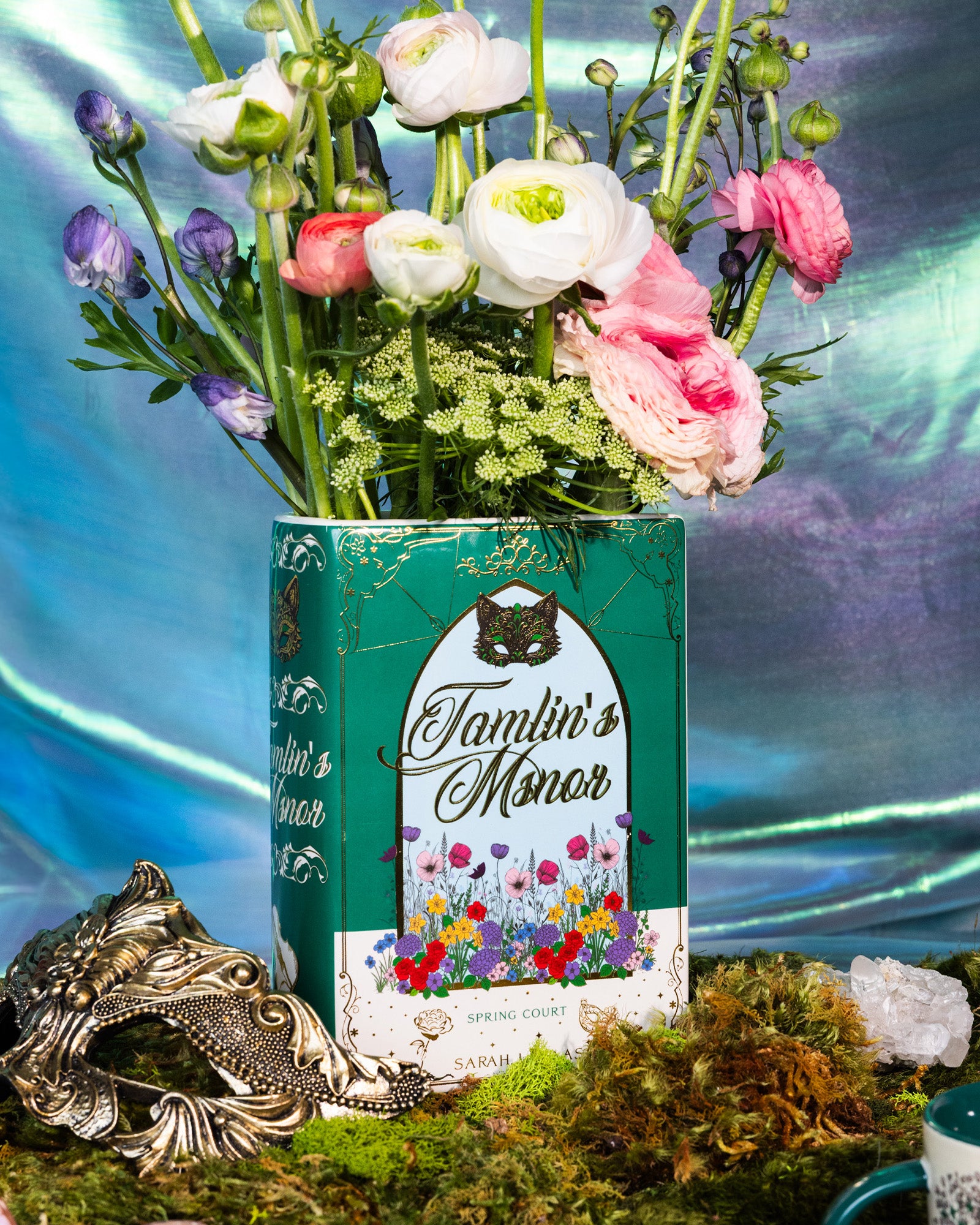 Book-shaped vase with 'Tamlin's Manor' design with flowers inside