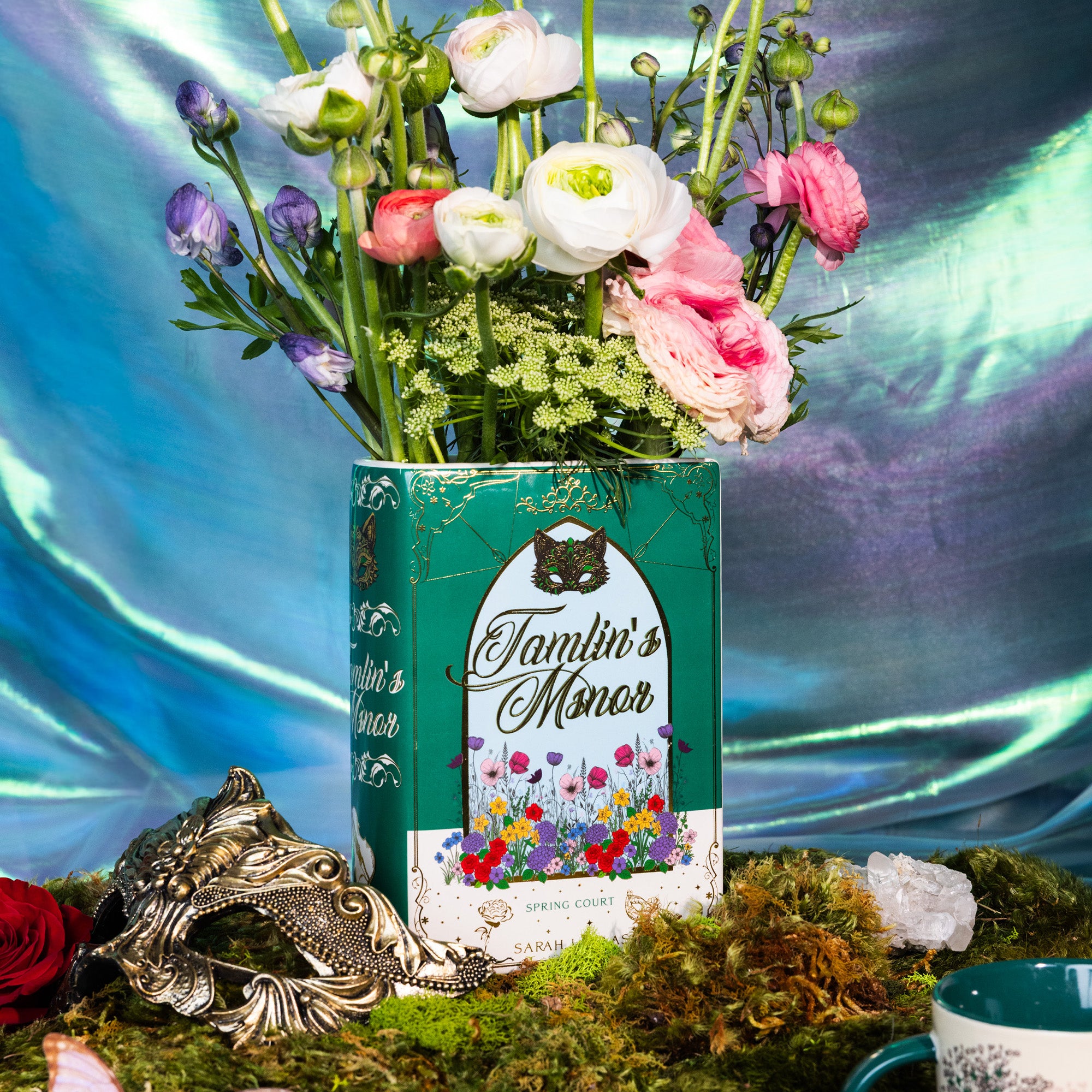 Book-shaped vase with 'Tamlin's Manor' design with flowers inside