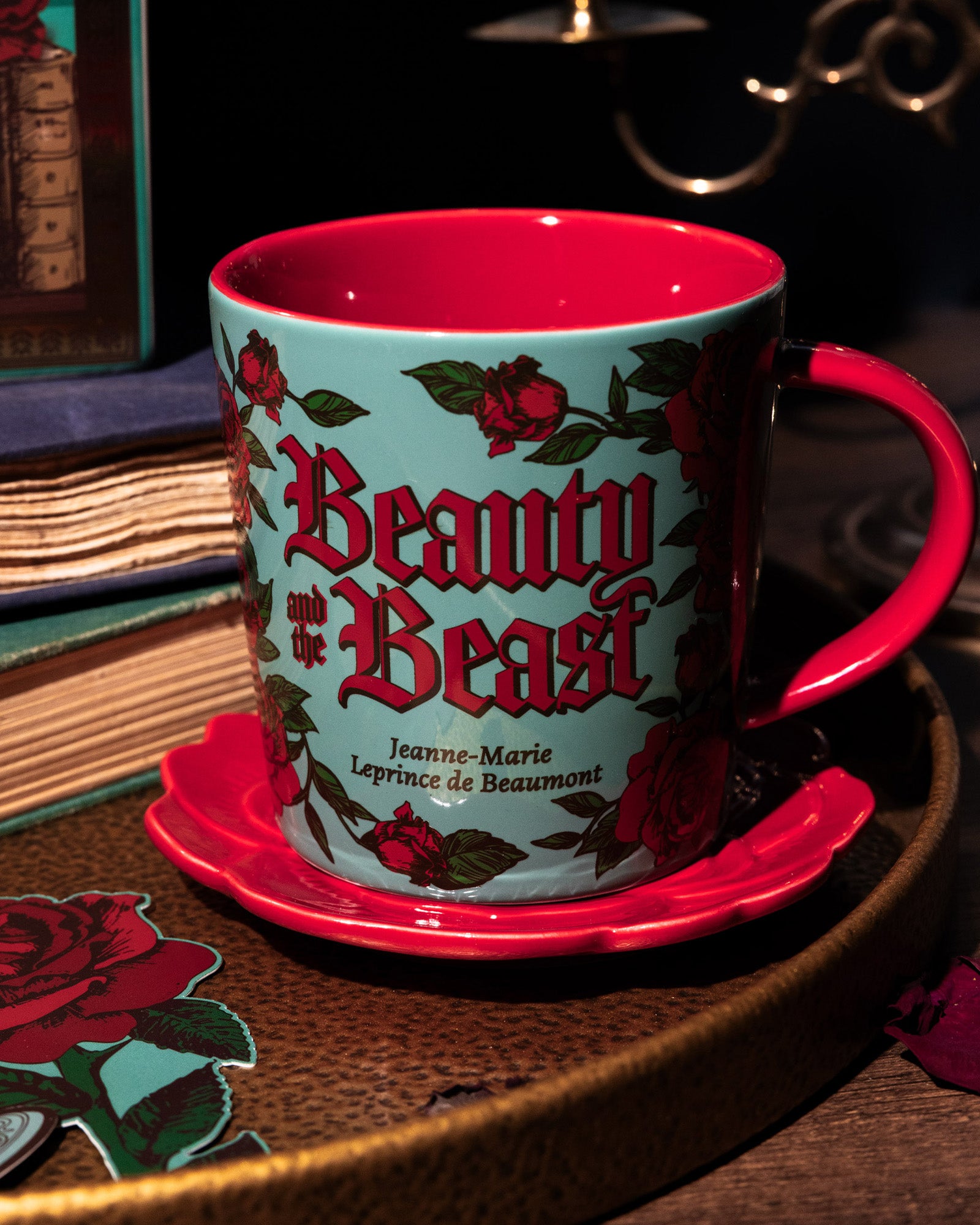Mug with 'Beauty and the Beast' design on a wooden surface with books in the background