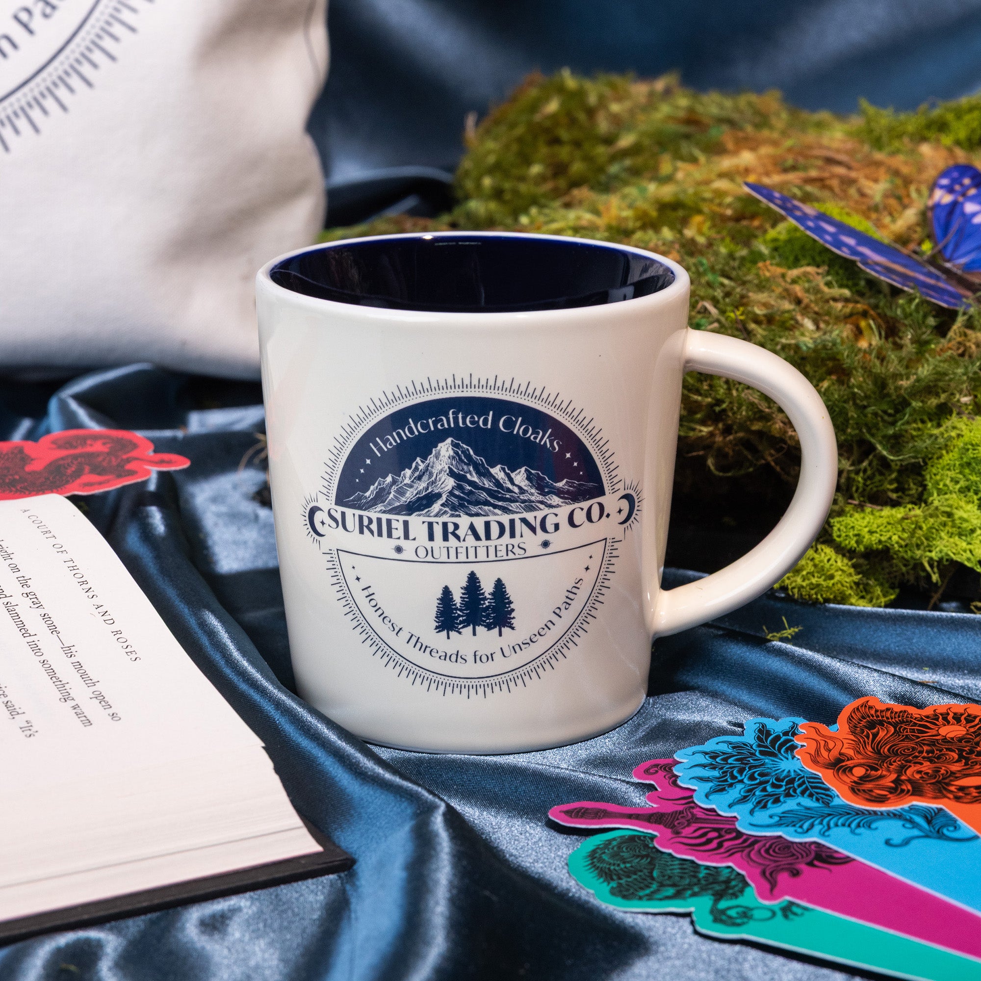 Beige mug with mountain and tree design and 'Suriel Trading Co.' text