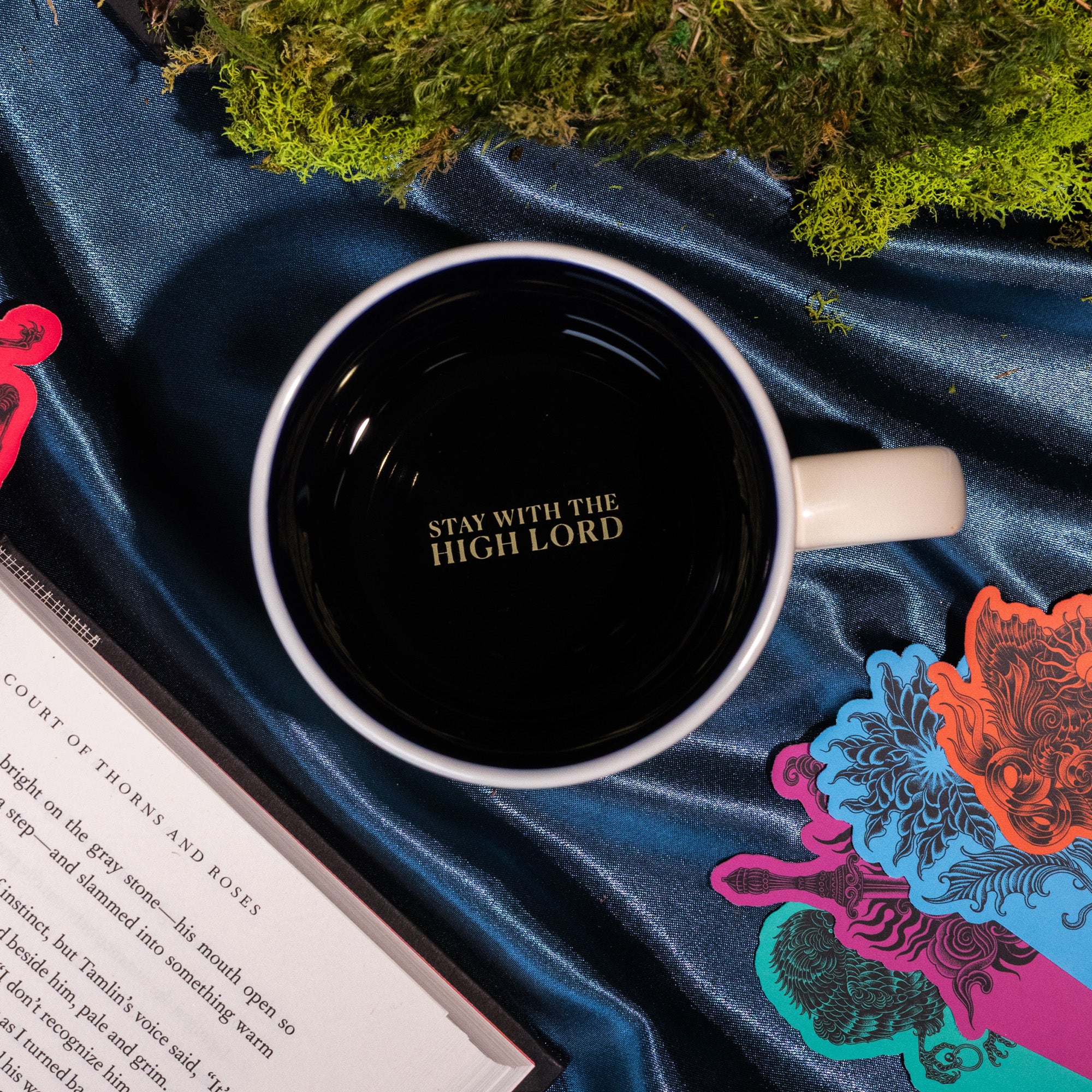 interior 'STAY WITH THE HIGH LORD' of Beige mug with mountain and tree design and 'Suriel Trading Co.' text