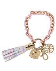 Pink and gold bracelet keychain with charms and a tassel on a white background