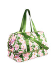 Floral patterned duffel bag with green handles on a white background
