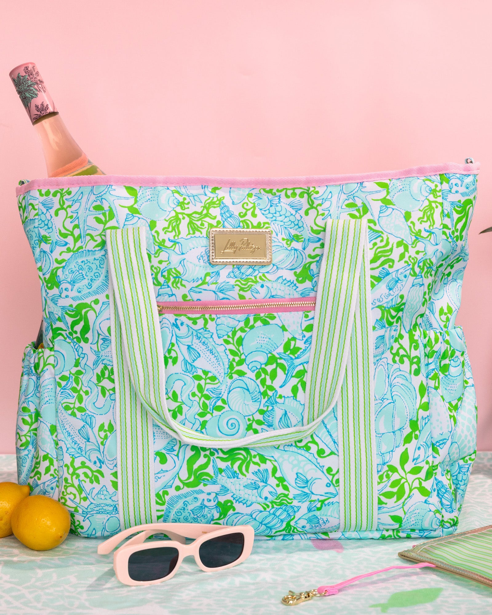 Floral patterned tote bag with green straps on a white background