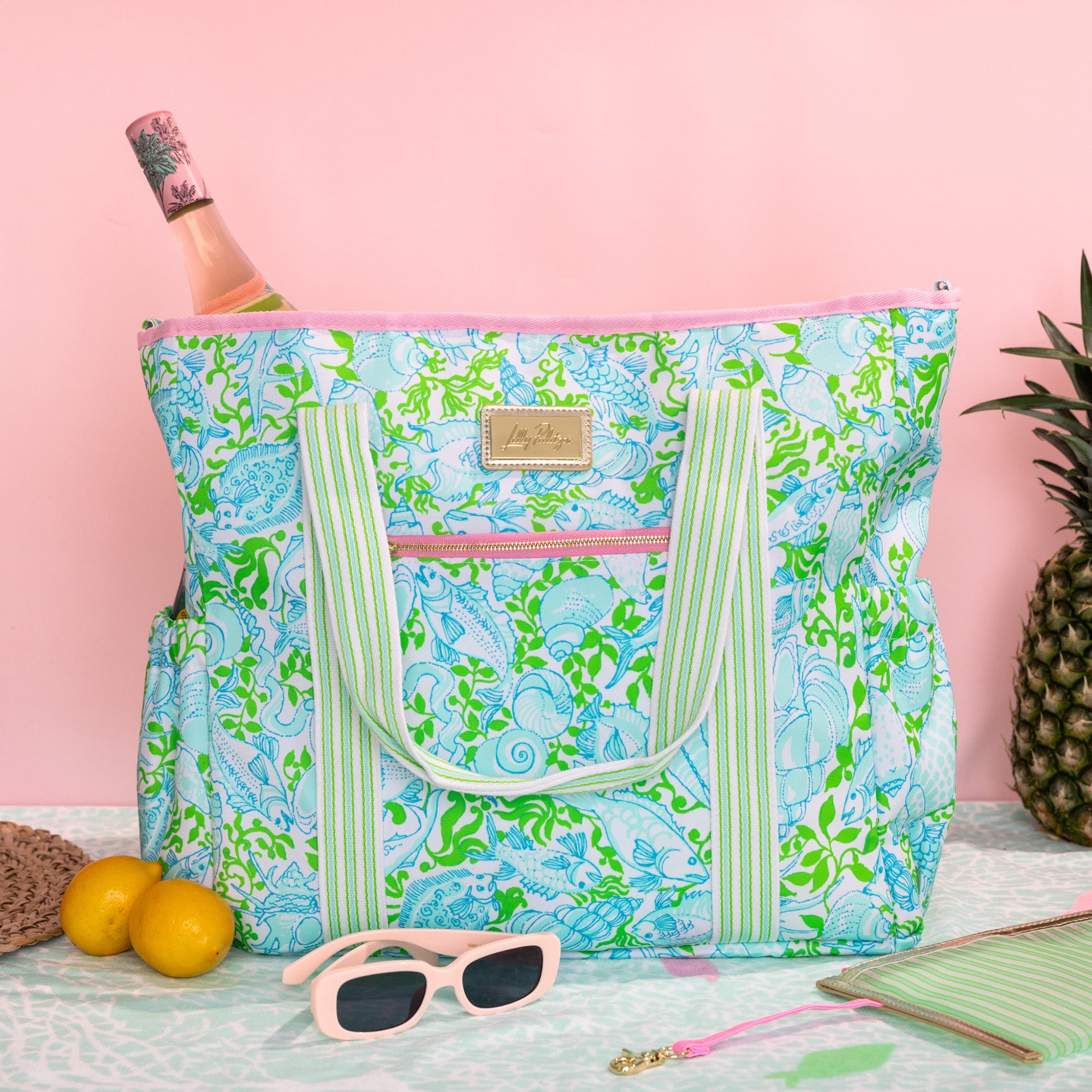 Floral patterned tote bag with green straps on a white background