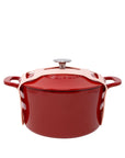 Red enameled cast iron Dutch oven with rose gold handles on a white background