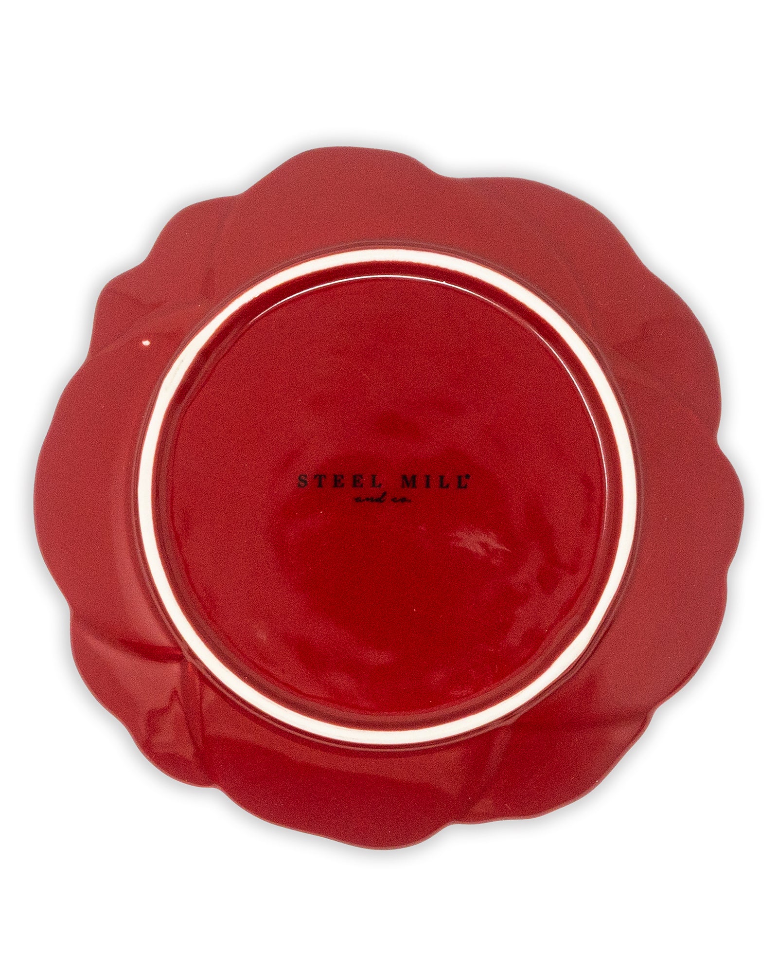 Red ceramic plate with scalloped edge on a white background