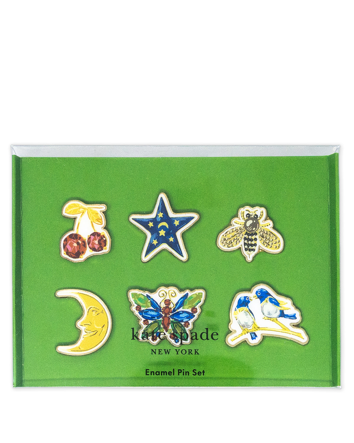Kate Spade New York enamel pin set in a green presentation box, featuring six pins: cherries, a star, a bee, a crescent moon, a butterfly, and a bird.
