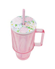Pink cup with floral lid and straw on a white background