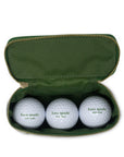 Three golf balls with 'kate spade new york' branding in a green case.