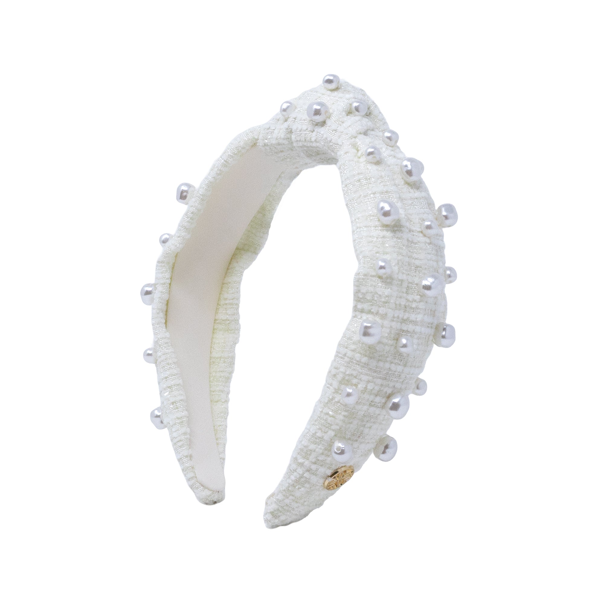 A white textured fabric headband adorned with small white faux pearls and a tiny gold clasp, shown against a plain white background.