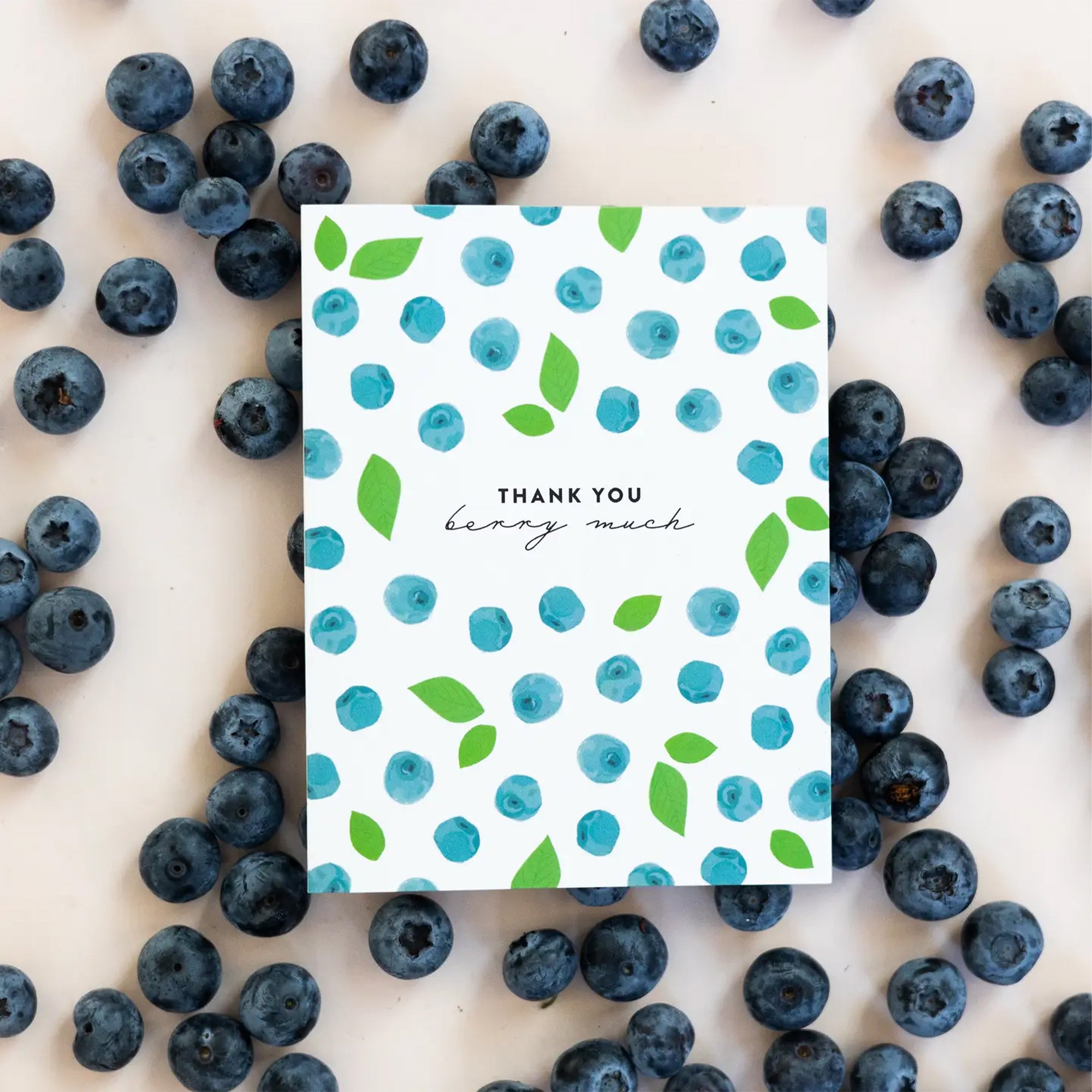 Note card with blueberry pattern surrounded by real blueberries