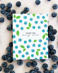 Note card with blueberry pattern surrounded by real blueberries