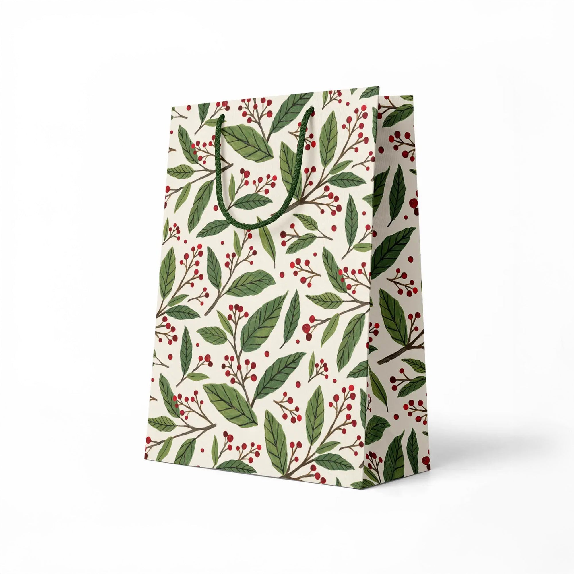 side view of gift bag with green leaf and red berry pattern on a white background