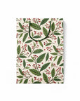 flattened gift bag with green leaf and red berry pattern on a white background