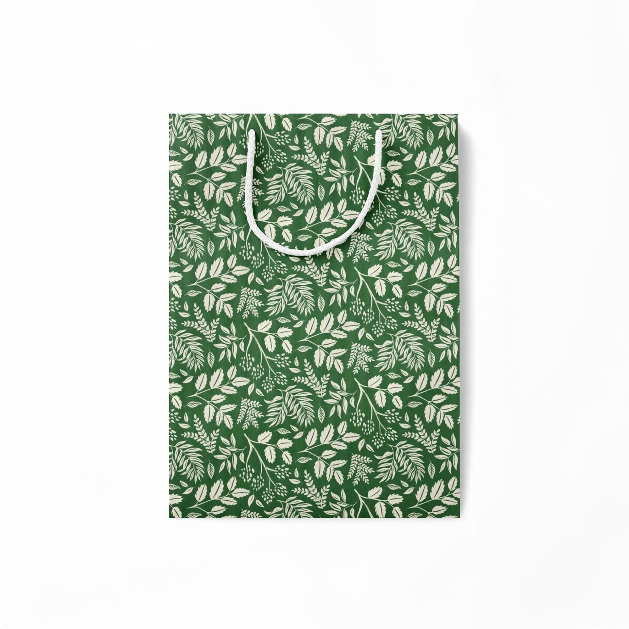 Flattened green paper gift bag with white leaf pattern on a white background