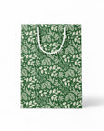 Green paper gift bag with white leaf pattern on a white background