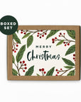 packaged Christmas card with green leaves and red berries and a brown envelope with 'Merry Christmas' on a white background