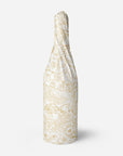 Decorative tissue paper with gold floral pattern wrapped around a bottle