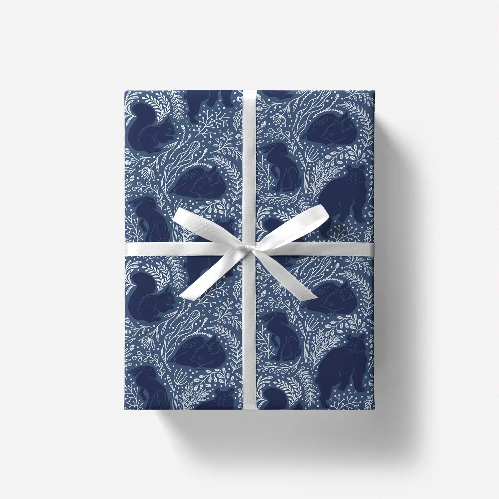 Gift box with blue pattern and white ribbon on a white background