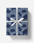 Gift box with blue pattern and white ribbon on a white background