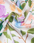 Floral fabric with colorful flowers and green leaves on a white background