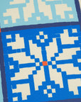 Close-up of a geometric patterned fabric with blue and beige colors.