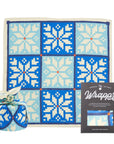 Gift wrap with blue and white pattern, wrapped present, and packaging on a white background