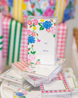 Stack of floral and checkered gift tags with a colorful background