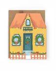 Card with a festive house illustration featuring wreaths and ribbons on a white background