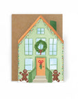 Christmas-themed house card with a wreath, gingerbread men, and a brown envelope.