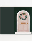 Flattened pink door with a wreath on a dark green background