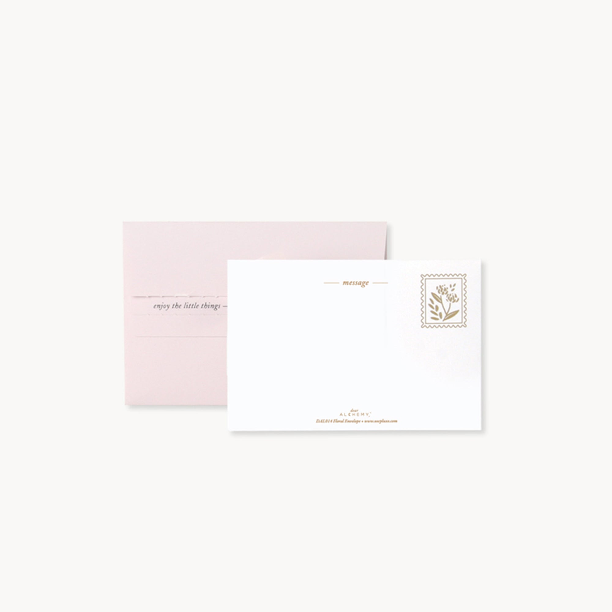 White card with gold text and pink envelope on a white background
