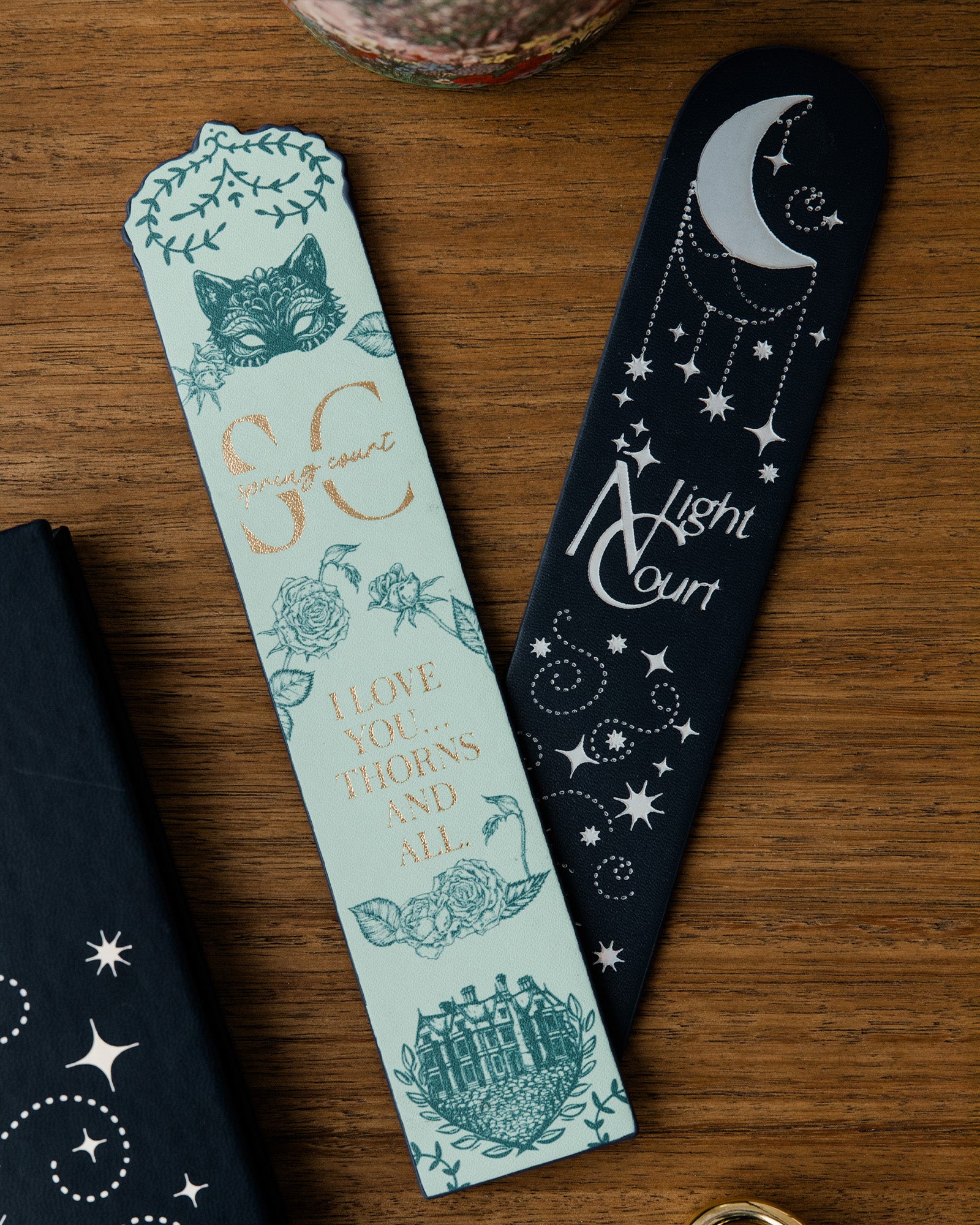 Two bookmarks with decorative designs on a wooden surface