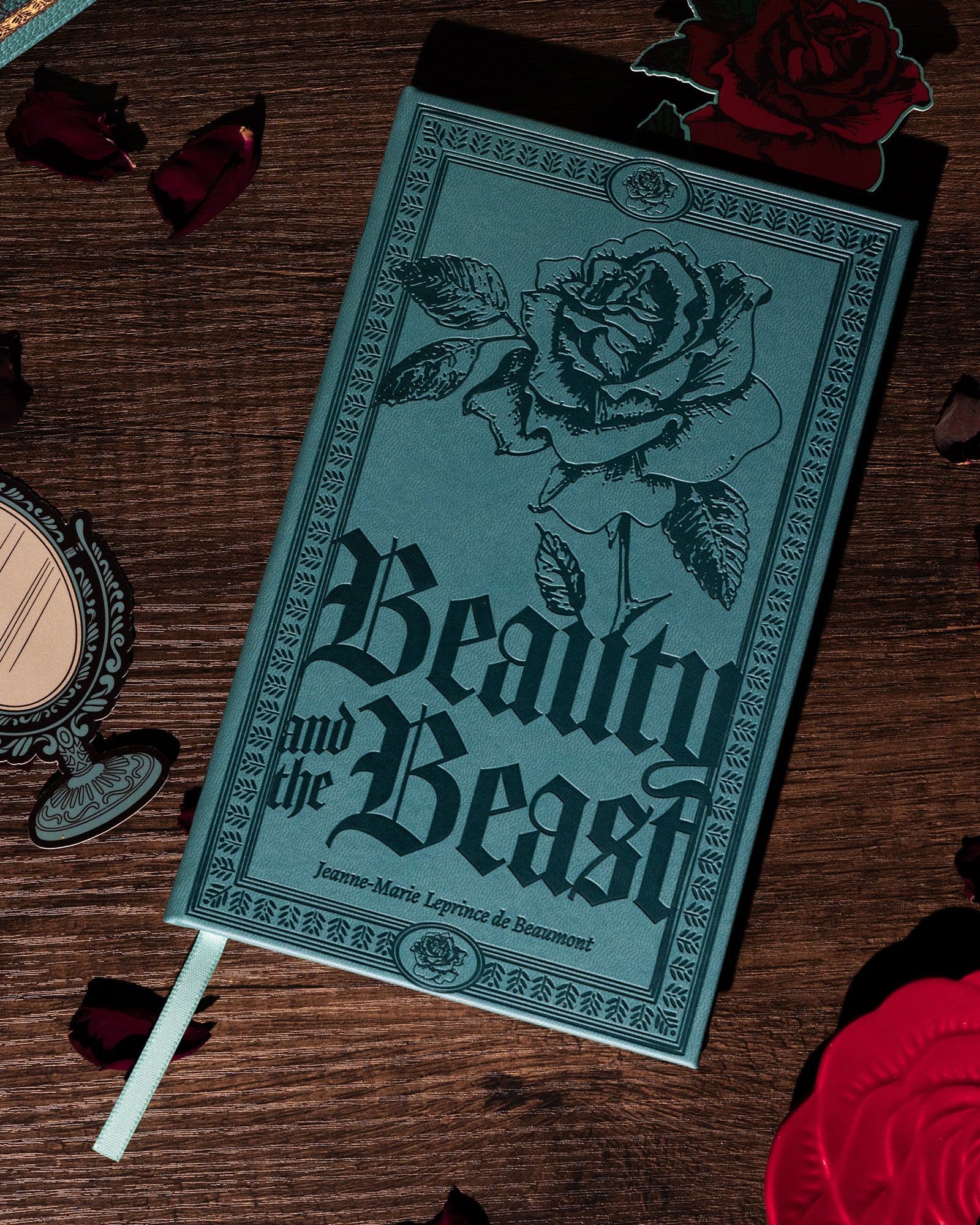 Teal notebook with rose design and 'Beauty and the Beast' text on a white background