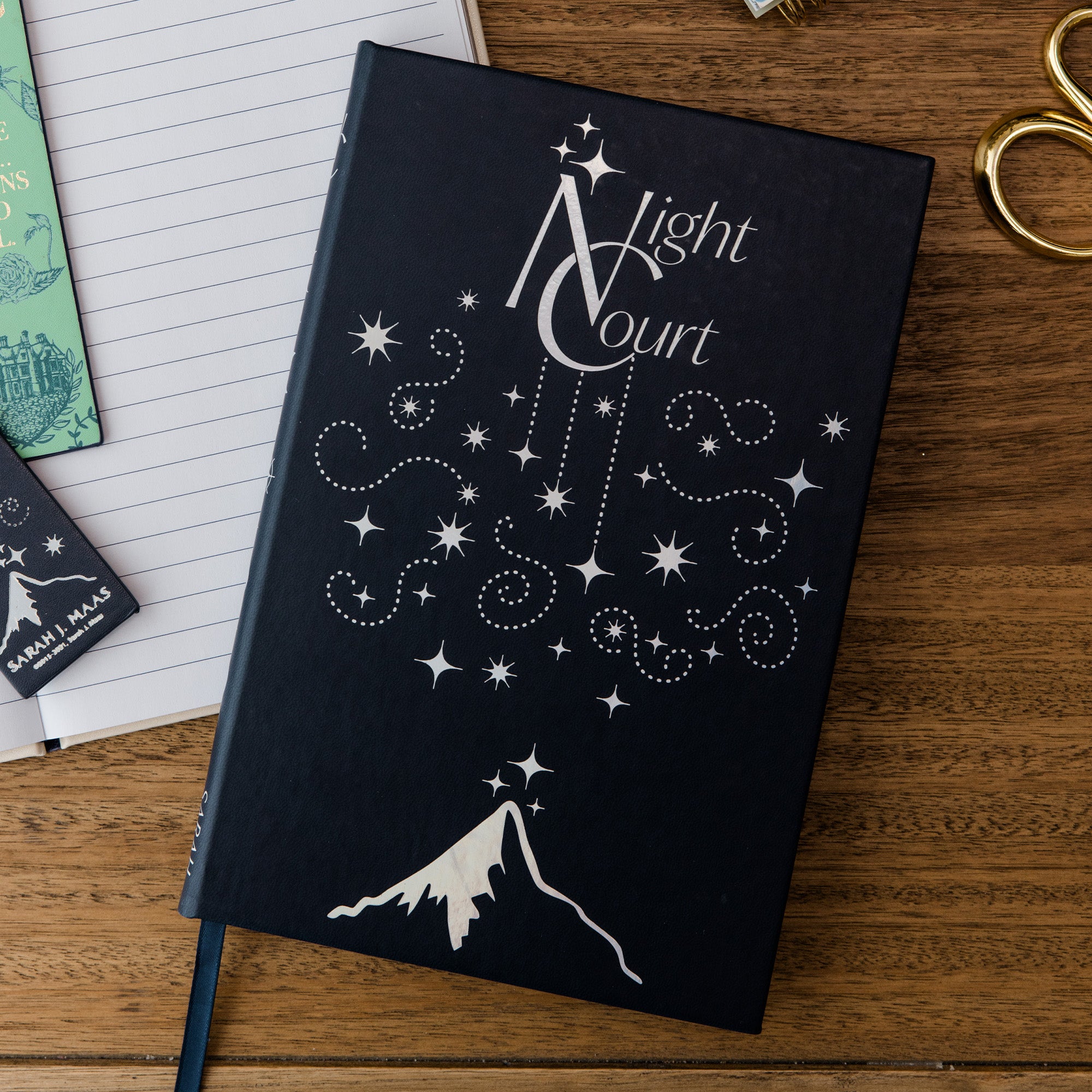 Black notebook with 'Light Court' design on a wooden surface