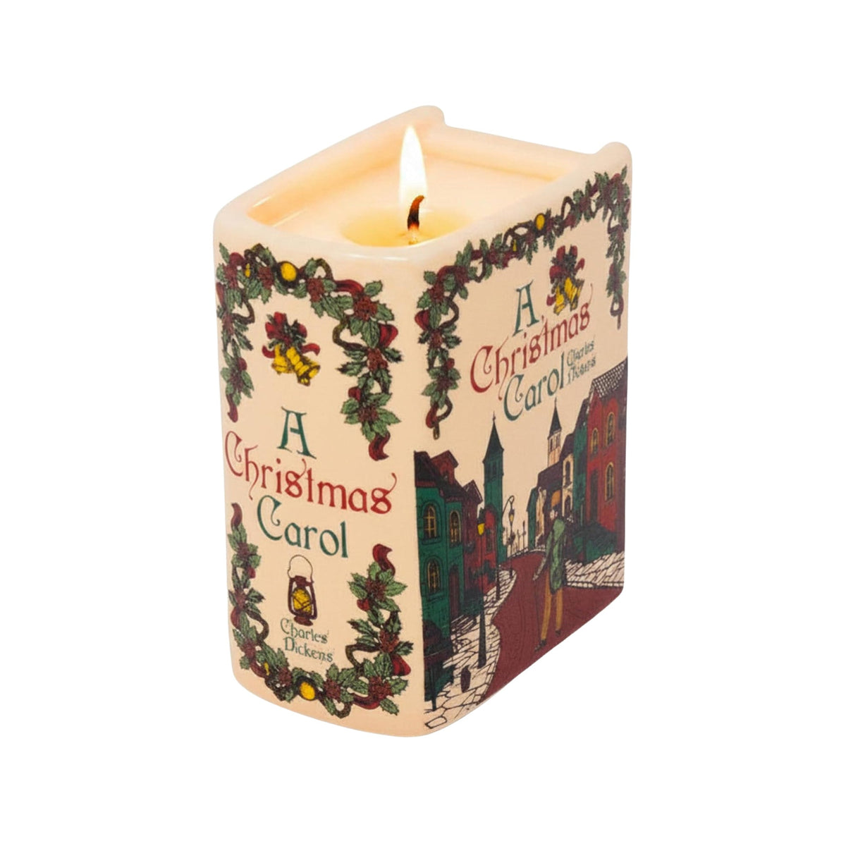 A lit square Christmas carol candle with a cream-colored wax body and printed holiday illustrations, including green holly garlands, red and green text reading 'A Christmas Carol,' and a winter village scene on the side.
