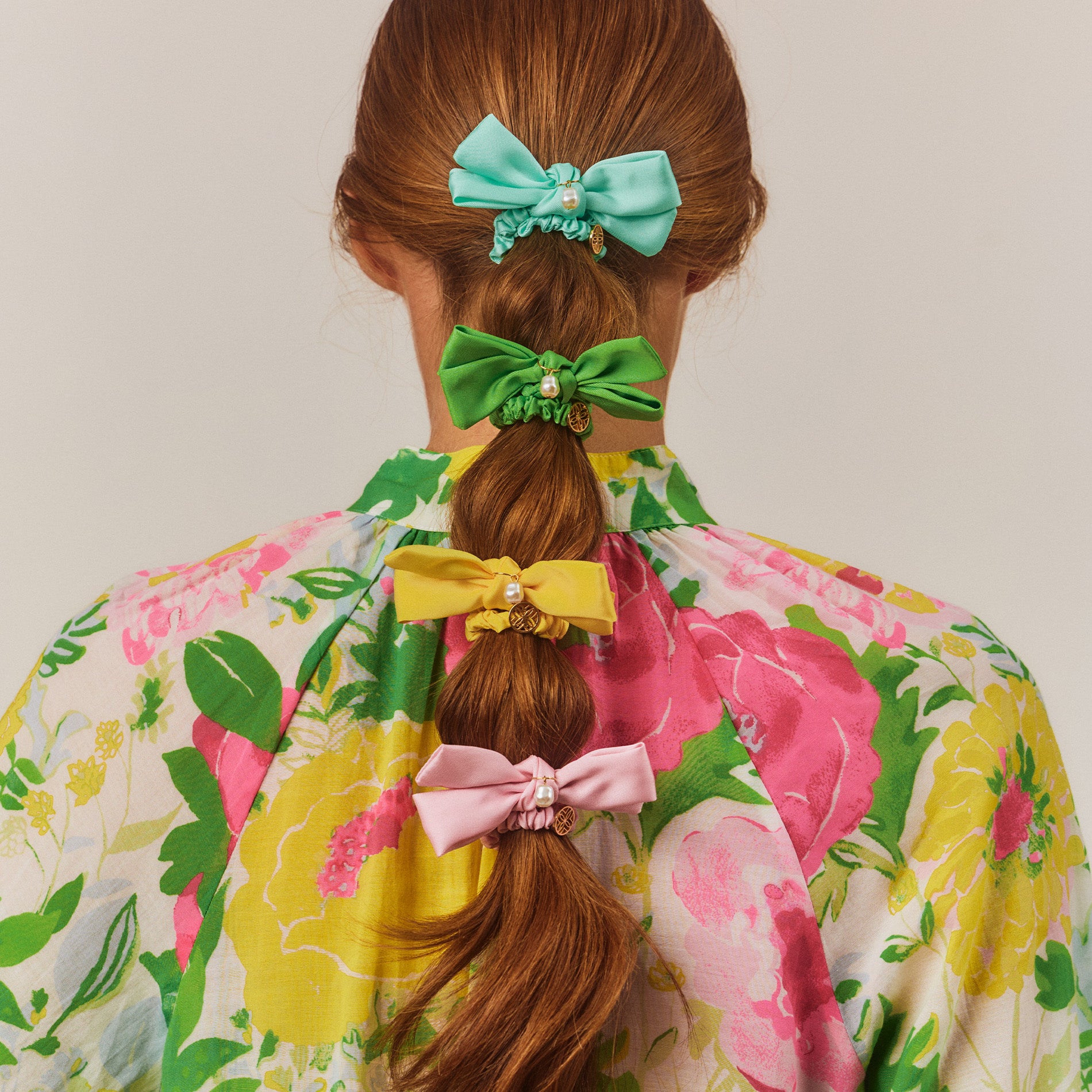 model wearing teal, green, yellow and light pink bow scrunchies