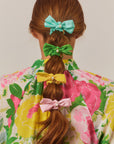 model wearing teal, green, yellow and light pink bow scrunchies