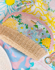 Floral-patterned pouch with a wicker base on a colorful background