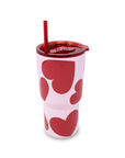Pink tumbler with red heart patterns and a red straw on a white background