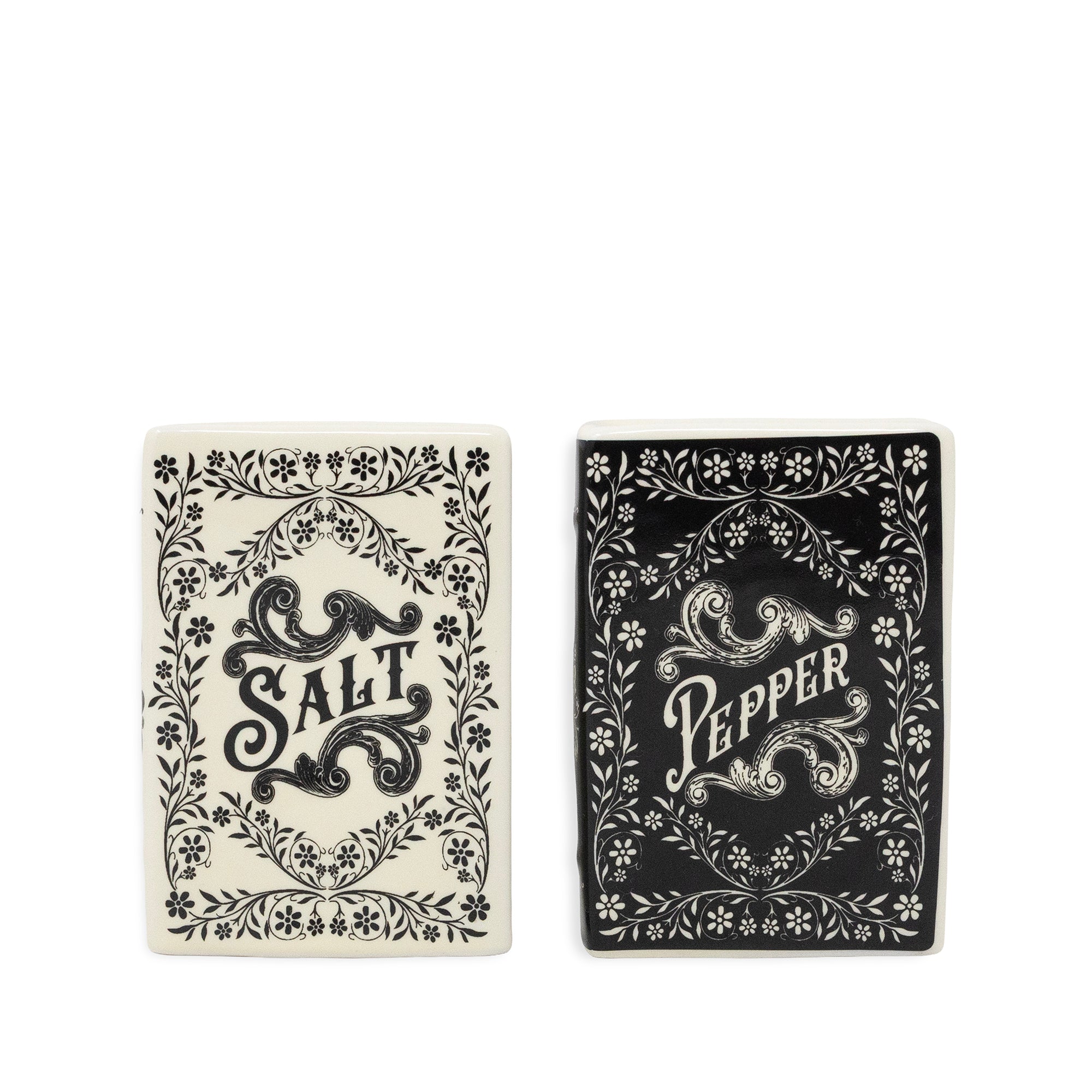 Two decorative rectangular items with ornate floral borders and central lettering, shown side by side on a white background. The left item reads "SALT" in black on an off-white background, and the right item reads "PEPPER" in white on a black background.