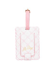 Pink luggage tag with scalloped edge design on a white background