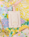 Pink luggage tag with 'Lilly Pulitzer' branding on a colorful floral background