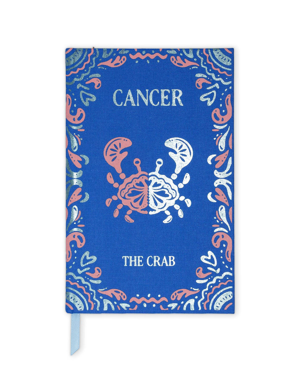 A blue hardcover journal or notebook featuring a zodiac design for Cancer 'The Crab'. The cover has a blue linen texture background with a coral pink and white crab illustration in the center, surrounded by a decorative paisley border.