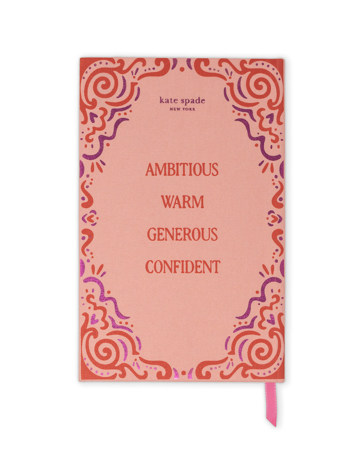 Kate Spade New York notebook with a coral pink cover, featuring a red and purple ornate border design and the words 'AMBITIONOUS WARM GENEROUS CONFIDENT' printed in red. A pink ribbon bookmark is visible at the bottom right.