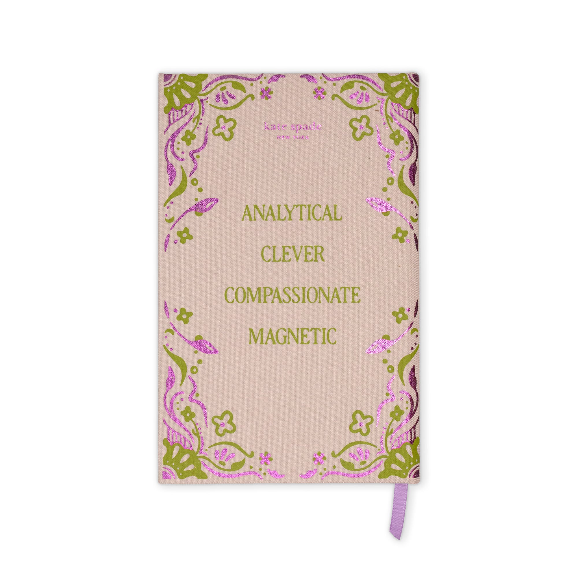 A pink notebook with a decorative border and gold text reading 'ANALYTICAL CLEVER COMPASSIONATE MAGNETIC' on the cover, with a purple ribbon bookmark hanging from the bottom right.